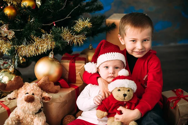 Портрет щасливих дітей з різдвяними подарунковими коробками та прикрасами. Двоє дітей розважаються вдома — стокове фото