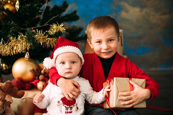 Porträt glücklicher Kinder mit weihnachtlichen Geschenkboxen und Dekorationen. Zwei Kinder haben Spaß zu Hause — Stockfoto