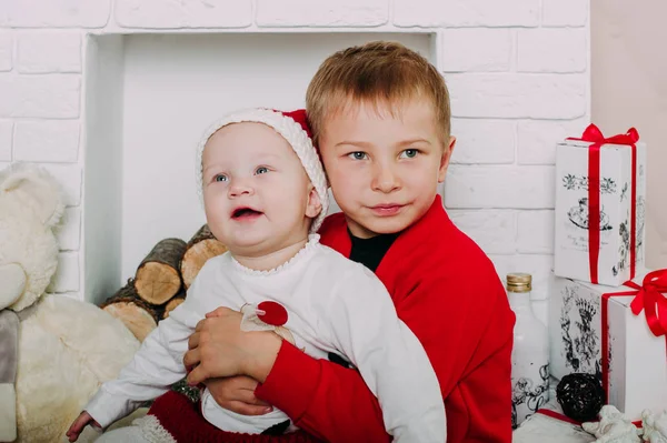 Портрет счастливых детей с рождественскими подарочными коробками и украшениями. Двое детей веселятся дома — стоковое фото