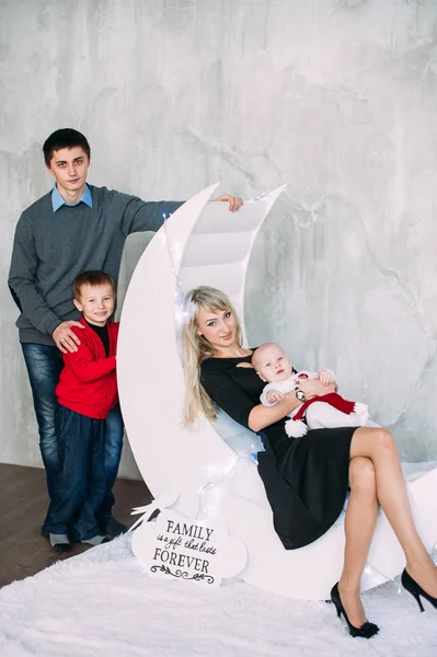 Retrato de familia amigable mirando a la cámara en la noche de Navidad — Foto de Stock