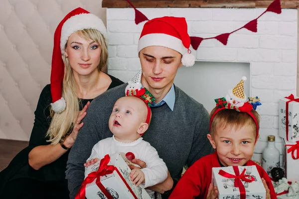 Retrato de familia amigable mirando a la cámara en la noche de Navidad — Foto de Stock