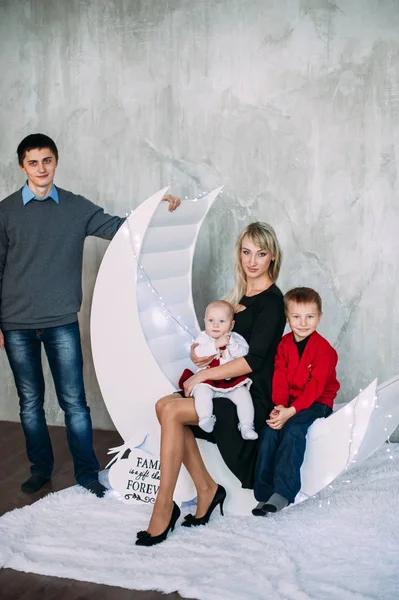 Retrato de familia amigable mirando a la cámara en la noche de Navidad — Foto de Stock