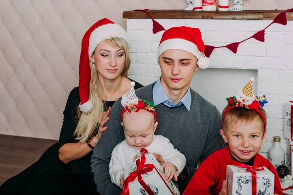 Retrato de familia amigable mirando a la cámara en la noche de Navidad — Foto de Stock