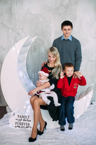 Retrato de familia amigable mirando a la cámara en la noche de Navidad — Foto de Stock