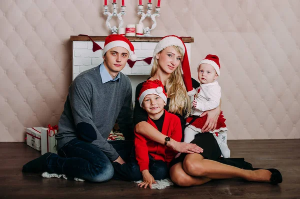 Retrato de familia amigable mirando a la cámara en la noche de Navidad — Foto de Stock