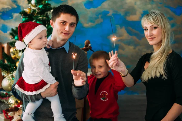 Porträtt av vänlig familj tittar på kameran på julafton — Stockfoto