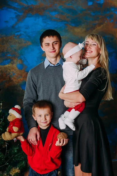 Retrato de familia amigable mirando a la cámara en la noche de Navidad —  Fotos de Stock