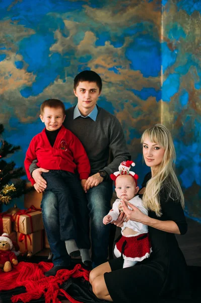 Retrato de família amigável olhando para a câmera na noite de Natal — Fotografia de Stock