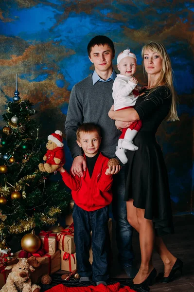 Retrato de família amigável olhando para a câmera na noite de Natal — Fotografia de Stock