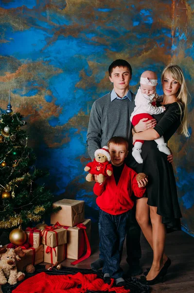 Retrato de familia amigable mirando a la cámara en la noche de Navidad — Foto de Stock