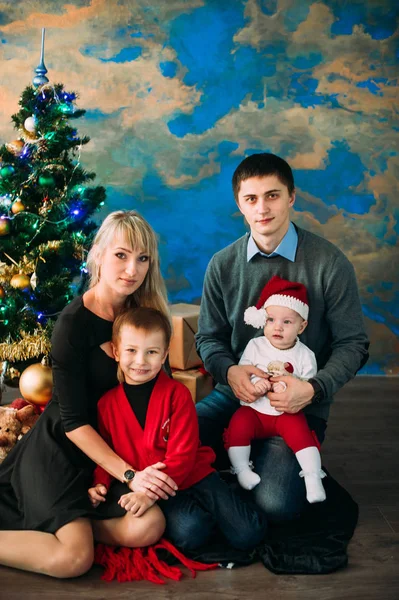 Retrato de familia amigable mirando a la cámara en la noche de Navidad — Foto de Stock