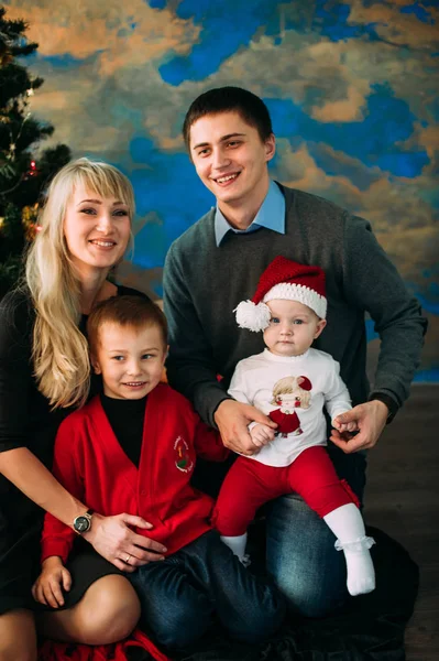 Retrato de familia amigable mirando a la cámara en la noche de Navidad — Foto de Stock