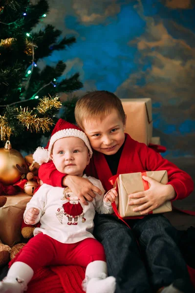 Ritratto di bambini felici con scatole regalo di Natale e decorazioni. Due bambini si divertono a casa — Foto Stock