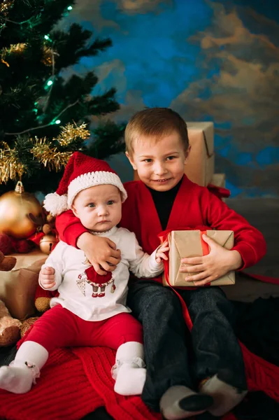 Ritratto di bambini felici con scatole regalo di Natale e decorazioni. Due bambini si divertono a casa — Foto Stock