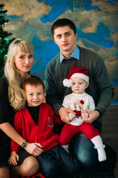 Retrato de familia amigable mirando a la cámara en la noche de Navidad — Foto de Stock