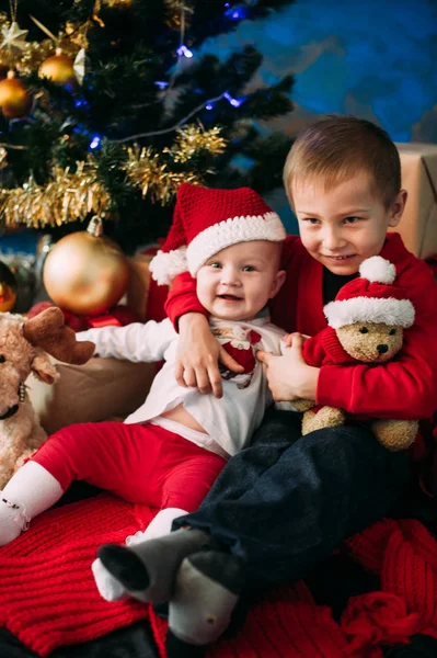 Retrato de crianças felizes com caixas de presente de Natal e decorações. Duas crianças se divertindo em casa — Fotografia de Stock