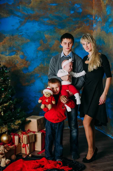 Retrato de família amigável olhando para a câmera na noite de Natal — Fotografia de Stock