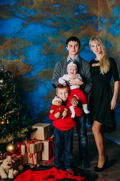 Retrato de familia amigable mirando a la cámara en la noche de Navidad — Foto de Stock