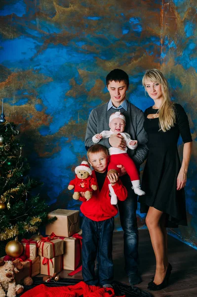 Retrato de família amigável olhando para a câmera na noite de Natal — Fotografia de Stock