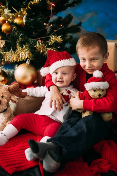Porträtt av glada barn med jul gåva lådor och dekorationer. två barn har roligt hemma — Stockfoto