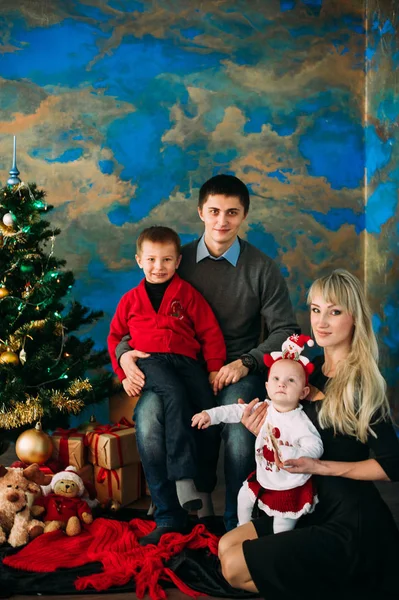 Retrato de família amigável olhando para a câmera na noite de Natal — Fotografia de Stock