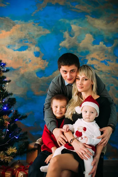 Retrato de família amigável olhando para a câmera na noite de Natal — Fotografia de Stock