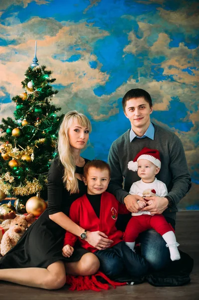 Retrato de família amigável olhando para a câmera na noite de Natal — Fotografia de Stock