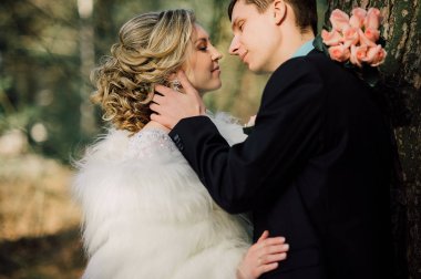 Parktaki gelin ve damat öpüşüyor. Doğadaki bir düğünde gelin ve damat öpüşüyor. Düğün çifti.