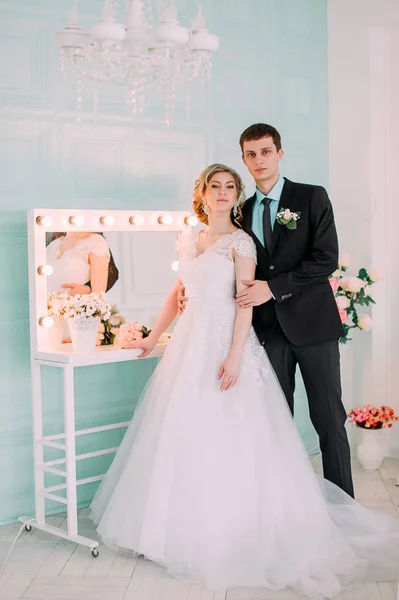 Um casal feliz. Fotografia de casamento atirar no estúdio branco com beijos de decoração de casamento, abraços — Fotografia de Stock