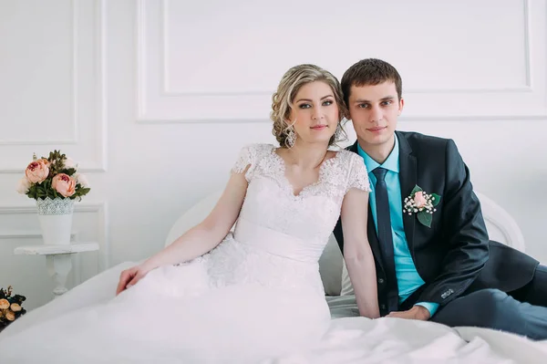 Um casal feliz. Fotografia de casamento atirar no estúdio branco com beijos de decoração de casamento, abraços — Fotografia de Stock