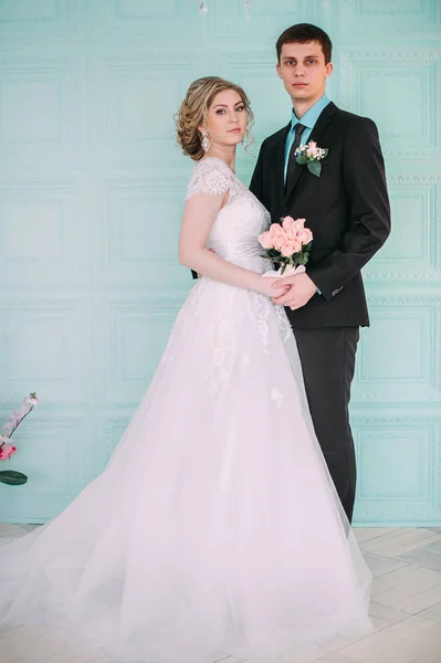 Lyckligt par. Bröllop fotosession i vit studion med bröllop inredning Kyssar, kramar — Stockfoto
