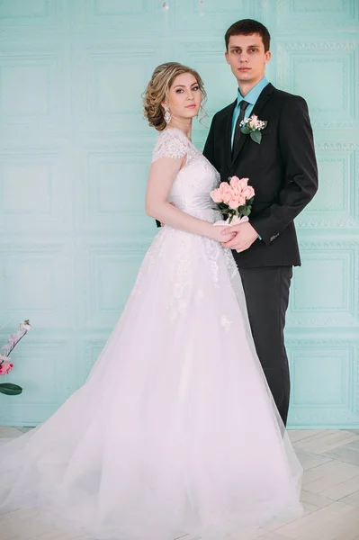 Um casal feliz. Fotografia de casamento atirar no estúdio branco com beijos de decoração de casamento, abraços — Fotografia de Stock