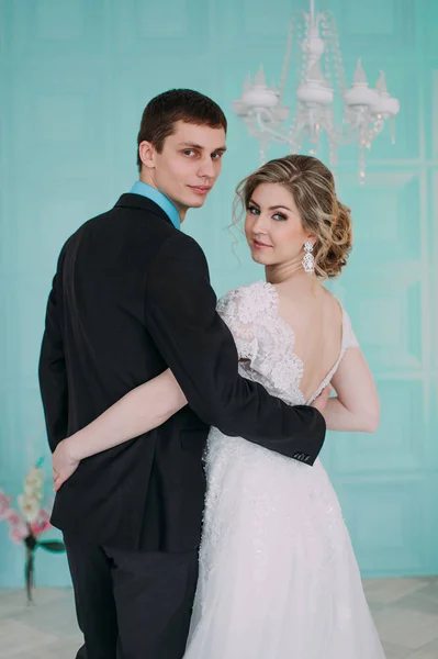 Happy couple. Wedding photo shoot in the white studio with wedding decor kisses, hugs — Stock Photo, Image