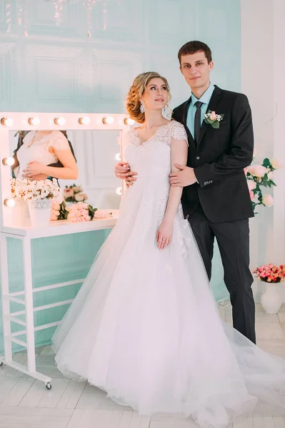 Happy couple. Wedding photo shoot in the white studio with wedding decor kisses, hugs — Stock Photo, Image