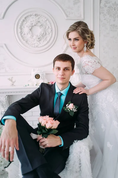 Um casal feliz. Fotografia de casamento atirar no estúdio branco com beijos de decoração de casamento, abraços — Fotografia de Stock