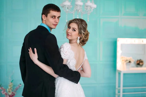 Um casal feliz. Fotografia de casamento atirar no estúdio branco com beijos de decoração de casamento, abraços — Fotografia de Stock