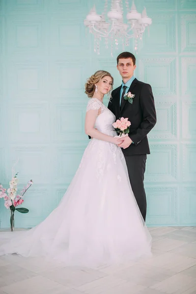 Счастливая пара. Свадебная фотосессия в белой студии с свадебным декором поцелуи, объятия — стоковое фото