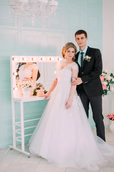 Um casal feliz. Fotografia de casamento atirar no estúdio branco com beijos de decoração de casamento, abraços — Fotografia de Stock