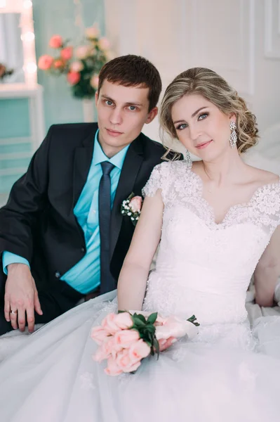 Happy couple. Wedding photo shoot in the white studio with wedding decor kisses, hugs — Stock Photo, Image