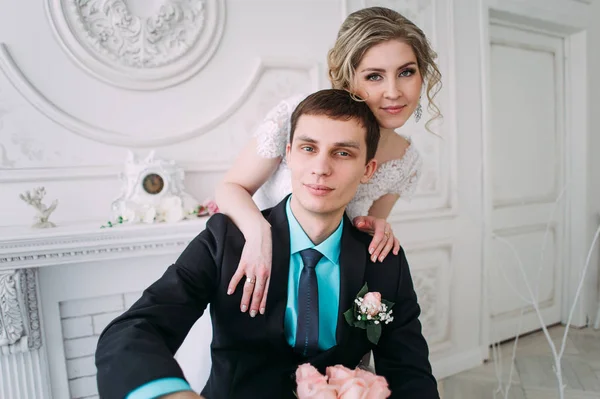 Um casal feliz. Fotografia de casamento atirar no estúdio branco com beijos de decoração de casamento, abraços — Fotografia de Stock