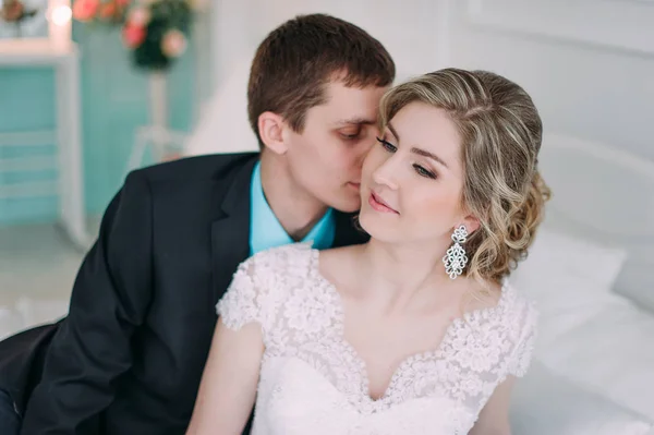 Um casal feliz. Fotografia de casamento atirar no estúdio branco com beijos de decoração de casamento, abraços — Fotografia de Stock