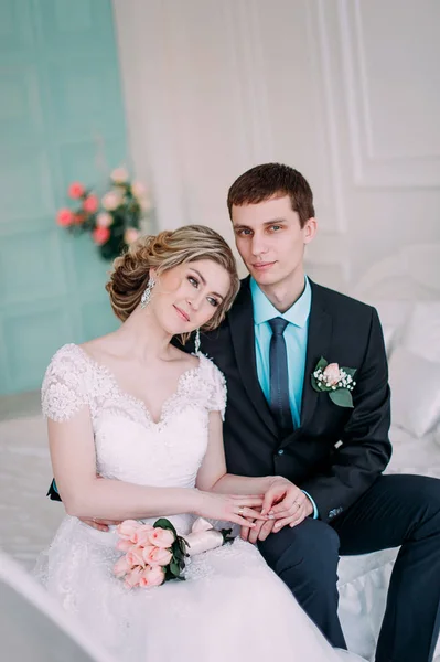 Um casal feliz. Fotografia de casamento atirar no estúdio branco com beijos de decoração de casamento, abraços — Fotografia de Stock