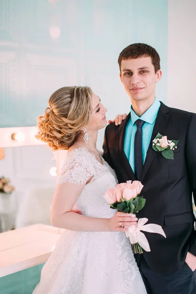 Gelukkige paar. Wedding fotoshoot in de witte studio met bruiloft decor kussen, hugs — Stockfoto