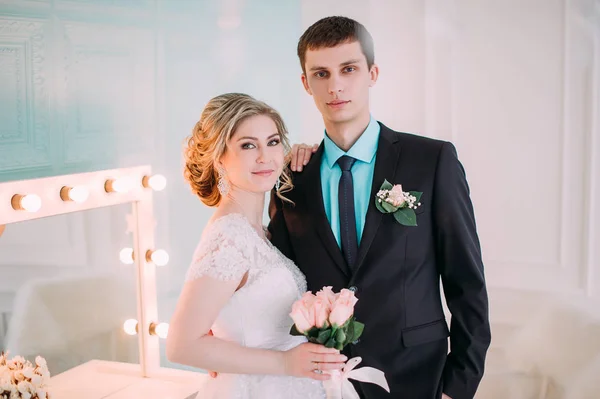 Щаслива пара. Весільна фотосесія в білій студії з весільним декором поцілунки, обійми — стокове фото
