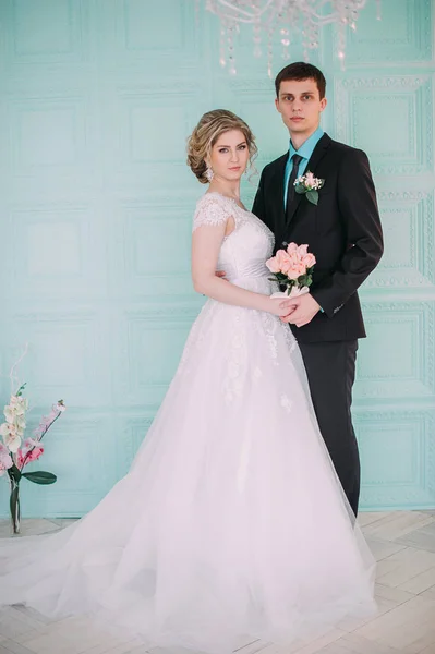 Um casal feliz. Fotografia de casamento atirar no estúdio branco com beijos de decoração de casamento, abraços — Fotografia de Stock