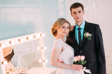 Mutlu çift. Fotoğraf çekimleri düğün dekor öpücükleri beyaz stüdyo düğün, hugs