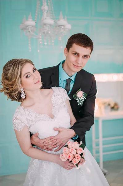 Um casal feliz. Fotografia de casamento atirar no estúdio branco com beijos de decoração de casamento, abraços — Fotografia de Stock