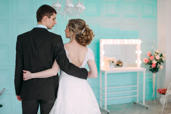 Ευτυχισμένο ζευγάρι. Γαμήλια φωτογράφηση στο λευκό στούντιο με γαμήλια διακόσμηση φιλιά, αγκαλιές — Φωτογραφία Αρχείου