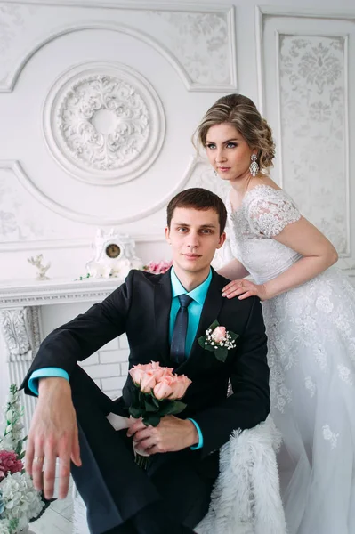 Счастливая пара. Свадебная фотосессия в белой студии с свадебным декором поцелуи, объятия — стоковое фото
