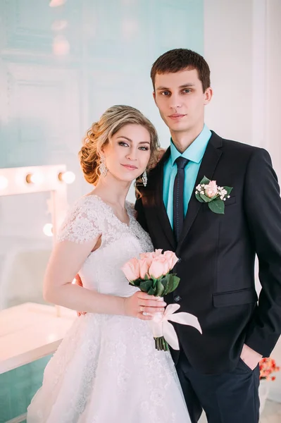 Um casal feliz. Fotografia de casamento atirar no estúdio branco com beijos de decoração de casamento, abraços — Fotografia de Stock